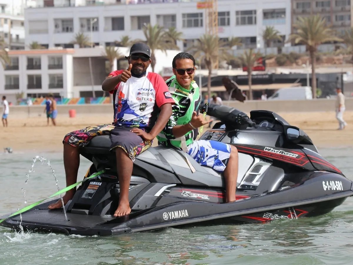 Visitors seated on a jet ski beside the beach