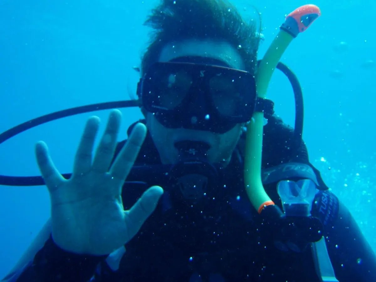 A diver wearing a mask and breathing equipment underwater