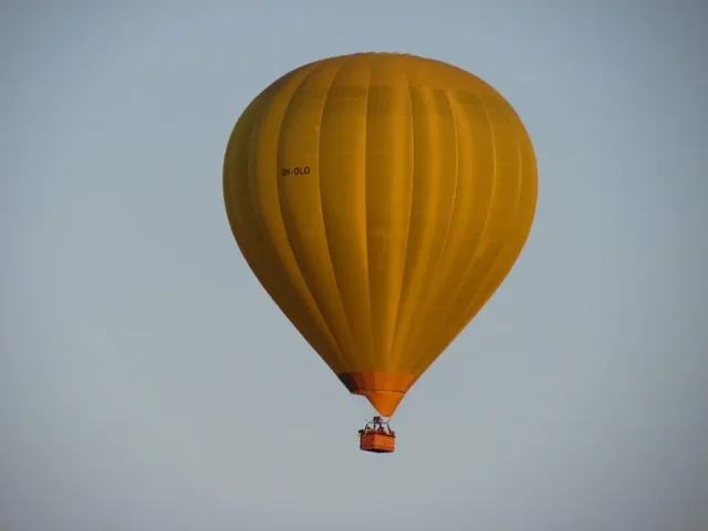 A yellow hot-air balloon in the sky