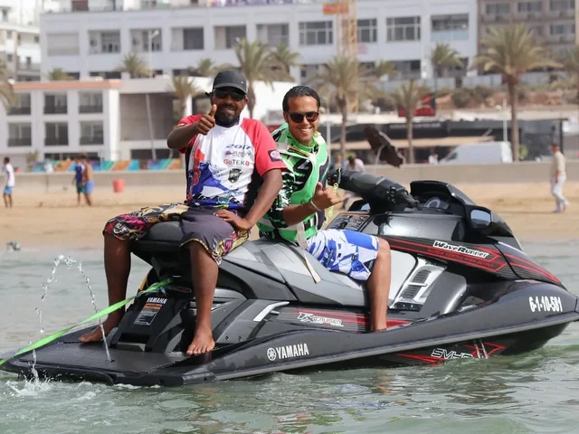 Visitors seated on a jet ski beside the beach